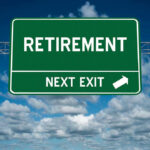 Green road sign reading retirement next exit sky background