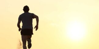 Silhouette of a man running on the beach during sunset
