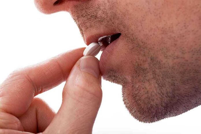 Close up of a man preparing to take a pill