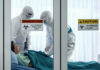 Terrifying Bird Flu Strain Jumps to Human Healthcare workers in protective gear in quarantine room.