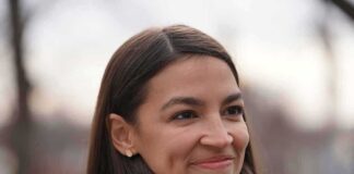 A smiling woman with long dark hair in a casual outdoor setting