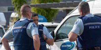 Three police officers discussing near a police vehicle