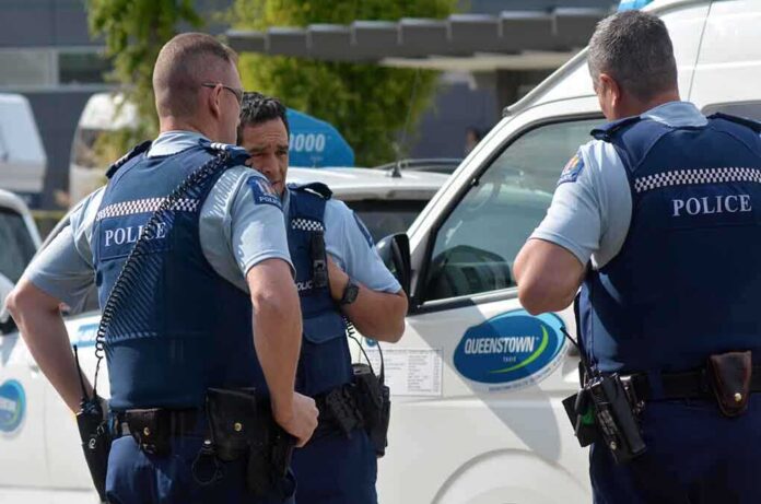 Three police officers discussing near a police vehicle