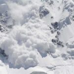 An avalanche occurring on a snowy mountain slope