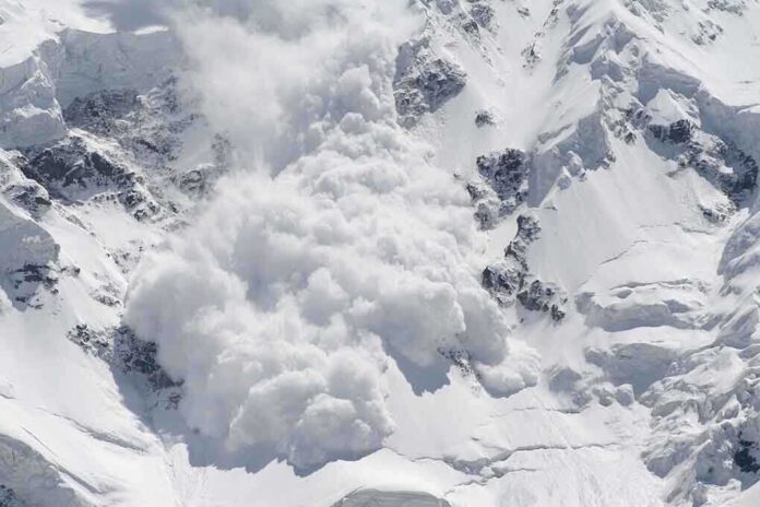 An avalanche occurring on a snowy mountain slope