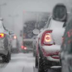 Cars stuck in traffic during a snowstorm with snow covering the vehicles