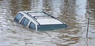 A partially submerged vehicle in floodwaters