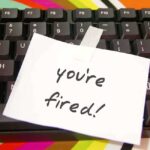 A note saying 'you're fired!' taped to a computer keyboard