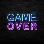 Game Over neon sign on brick wall.