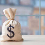 Money bag with dollar sign on table.