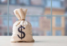 TRUMP Drops $10B Bombshell Money bag with dollar sign on table.