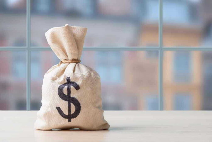 Money bag with dollar sign on table.