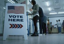 SHOCKING Discovery: Non-Citizens Actually Cast Ballots In Michigan Sign reading Vote Here in a polling station.