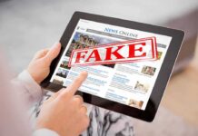 Machine Law Panic Hits Courtrooms Person holding a tablet displaying a news website with a 'FAKE' stamp