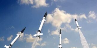 Multiple missiles launching into a cloudy sky