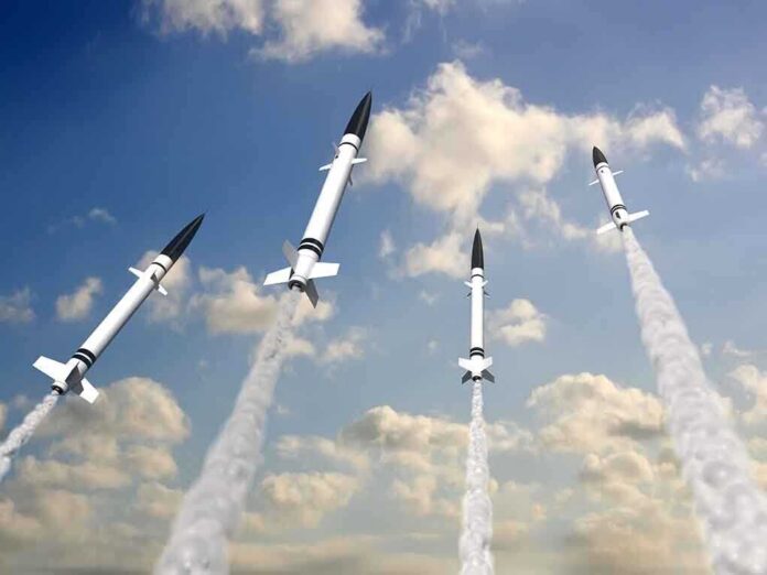 Multiple missiles launching into a cloudy sky