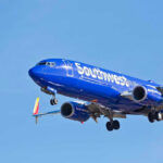 Southwest Airlines plane flying in blue sky.
