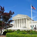 Supreme Court building with American flag and surrounding greenery