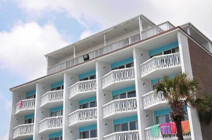 Exterior view of a beachfront hotel with balconies and colorful towels hanging