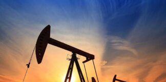 Silhouetted oil pumps against a colorful sunset sky