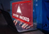 Hacker Heist: Schools Held HOSTAGE! Warning sign System Hacked on laptop screen.