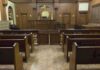 NFL STAR ACQUITTED – Justice System Doubts SOAR Interior view of an empty courtroom with wooden benches and a judges bench