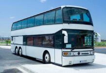 140 MPH Buses: Insane California Plan! A white double-decker bus parked in an urban area under a clear blue sky