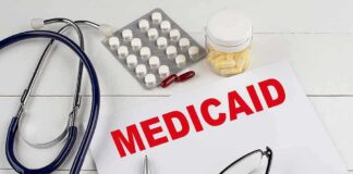Medical documents with the word 'Medicaid' prominently displayed alongside a stethoscope and medication