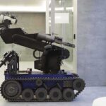 A robotic arm mounted on a tracked base in a modern workspace