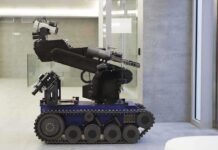 Ukraine’s ALL-ROBOT WIN—No Troops Needed! A robotic arm mounted on a tracked base in a modern workspace